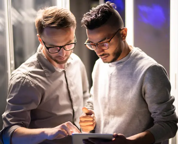 Dois homens de pé manuseando um tablet